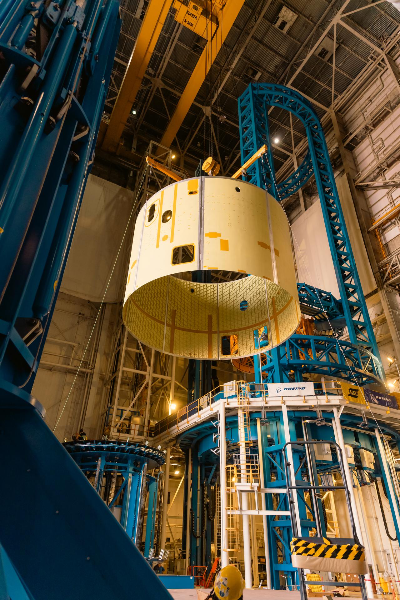 Teams at Michoud Assembly Facility in New Orleans load the engine section barrel into the vertical assembly center on Aug. 5, 2026. The engine section will be used on the SLS (Space Launch System) rocket’s core stage for the agency’s Artemis V mission. On the vertical assembly center tooling, teams will mate the flight hardware to a ring, which will serve as an attachment point for the liquid hydrogen tank later in the production process.    The engine section is one of five major elements that make up the 212-foot-tall SLS rocket stage; and houses various avionic systems, the engine thrust structure, and four RS-25 engines. The core stage produces more than two million pounds of thrust to help launch NASA’s Orion spacecraft, astronauts, and supplies beyond Earth’s orbit and to the lunar surface for Artemis.